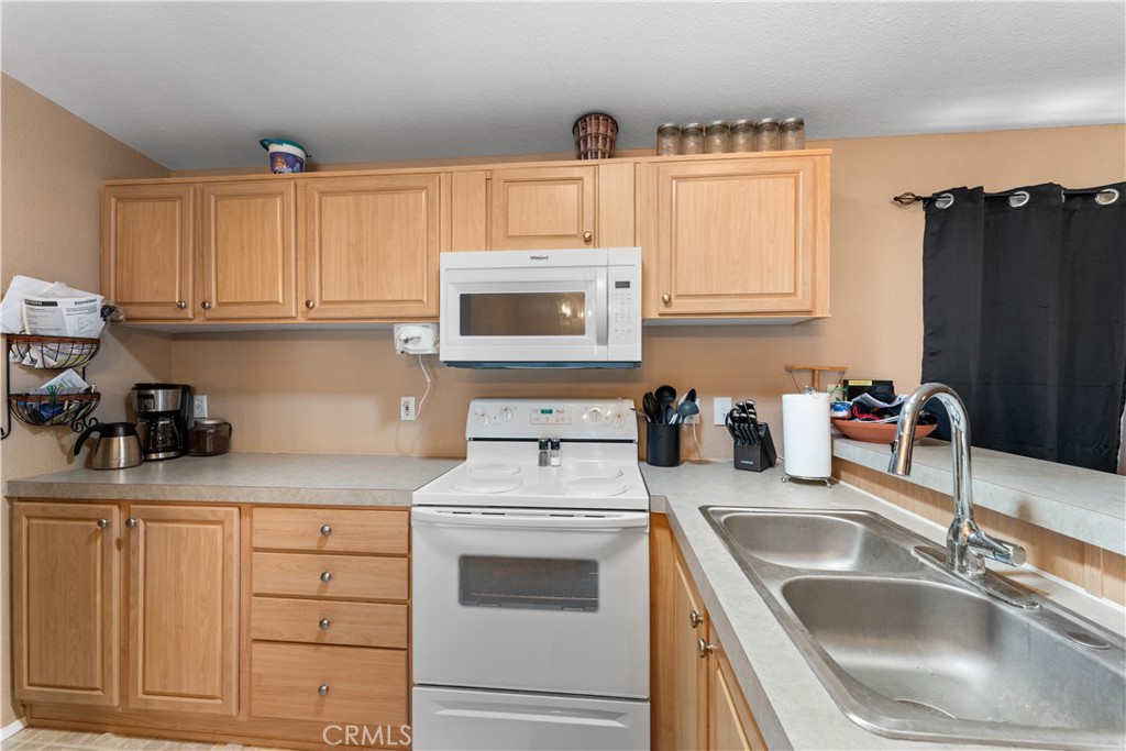 5900 Colorado River Road, Unit 18 Blythe, CA 92225 - Photo 14 of 58 a kitchen with granite countertop a sink dishwasher a stove and cabinets with wooden floor