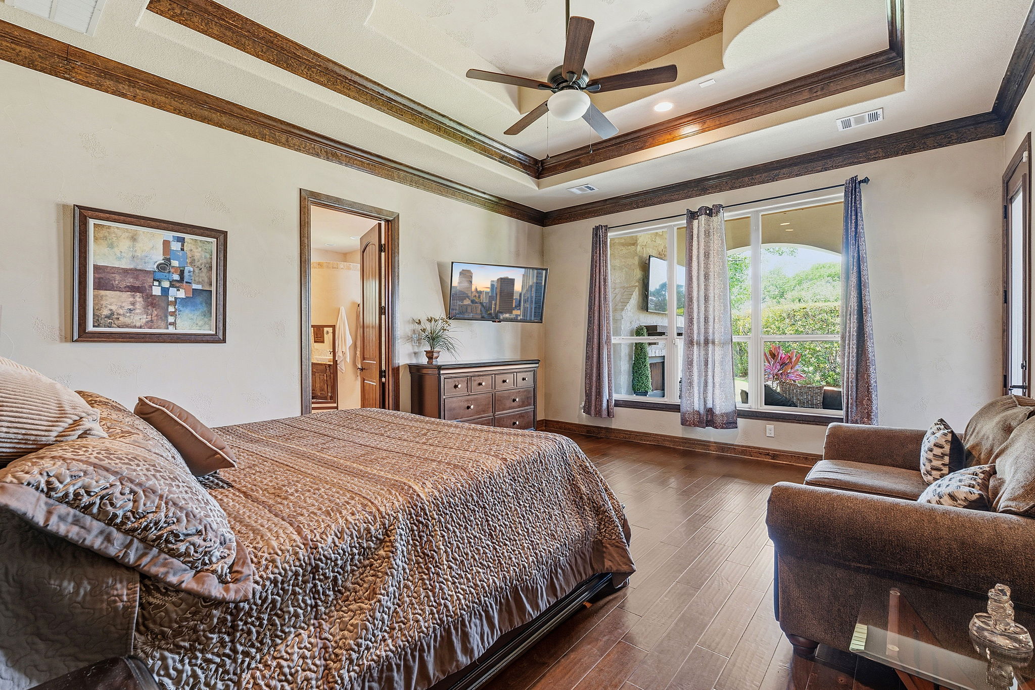 816 Brave Face Street Leander, TX 78641 - Photo 15 of 40 Elegant crown molding accents a bedroom featuring rich hardwood flooring and a refreshing ceiling fan.