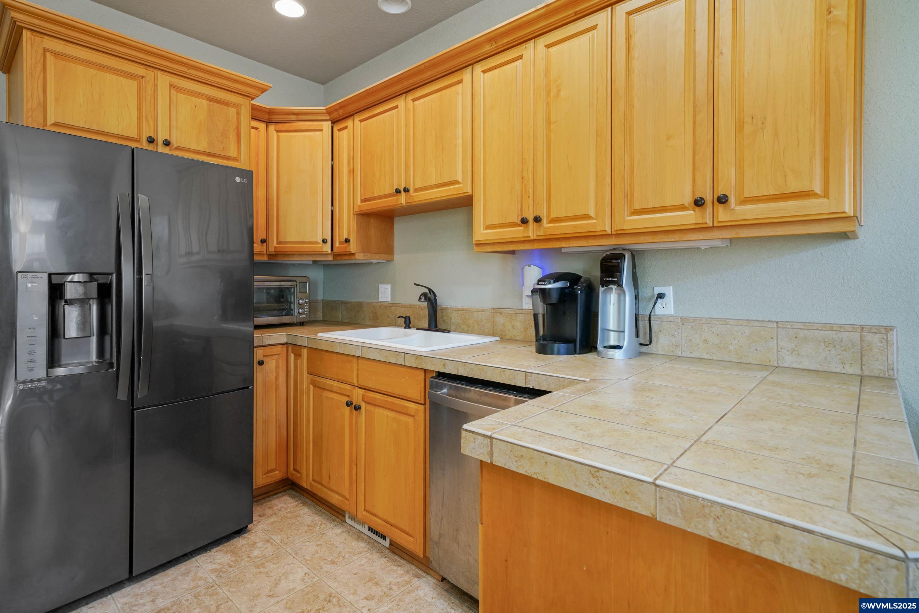 353 Northwest Reed Lane Dallas, OR 97338 - Photo 17 of 45 a kitchen with stainless steel appliances granite countertop a refrigerator sink and cabinets
