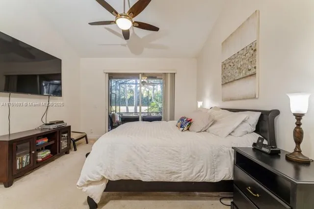 a bedroom with a bed a flat screen tv and a window