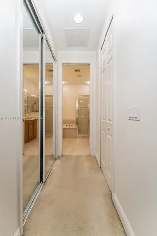 a view of a hallway with a livingroom and a bathroom