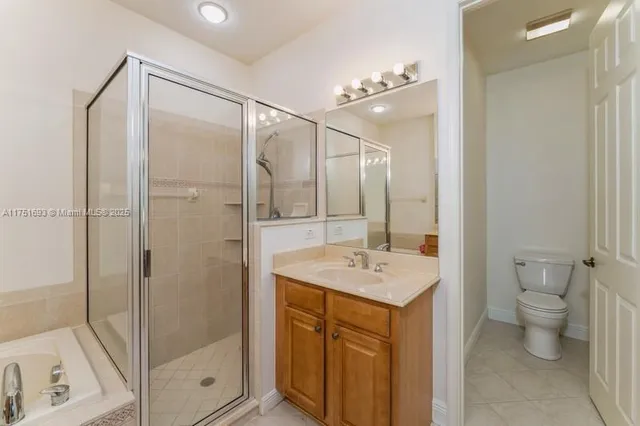 a bathroom with a shower sink mirror and toilet