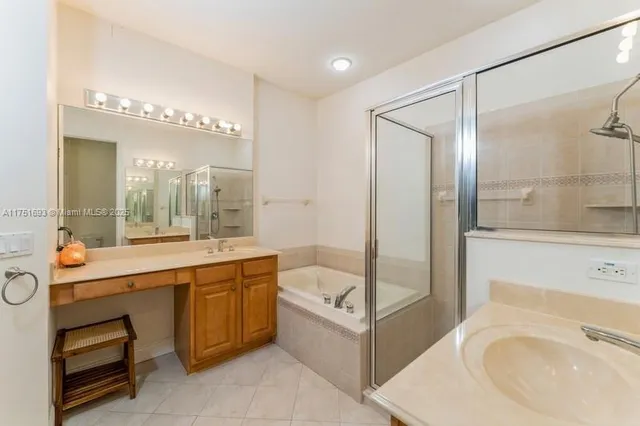 a bathroom with a tub sink shower and mirror
