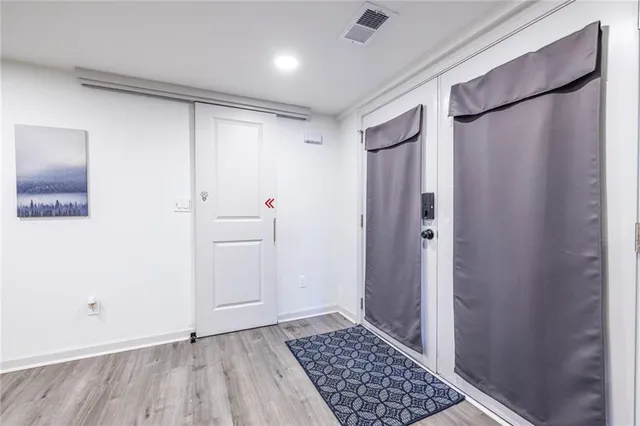 a kitchen with stainless steel appliances a dining table chairs and wooden floor