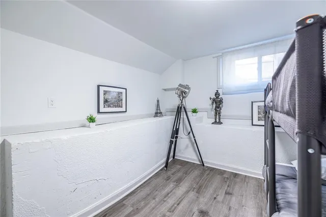 a view of a hallway with wooden floor and closet