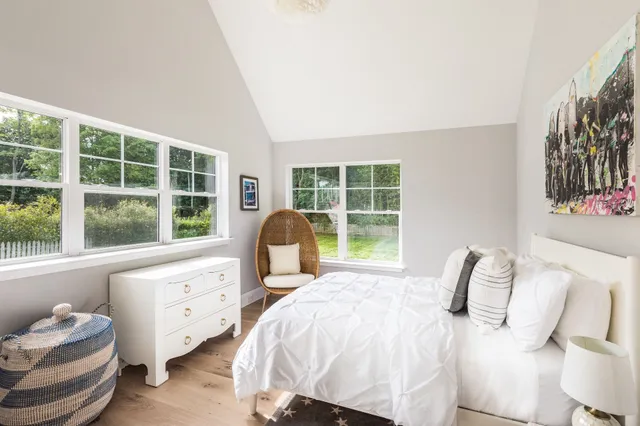 a bedroom with a bed and a large window