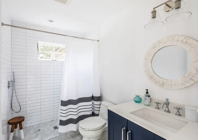a bathroom with a sink a toilet and shower