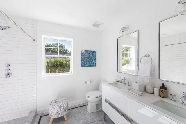 a bathroom with a granite countertop sink mirror and a toilet