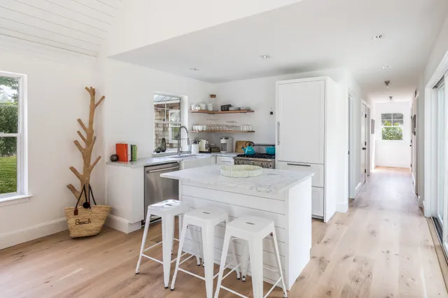 a kitchen with stainless steel appliances kitchen island granite countertop a table and chairs in it