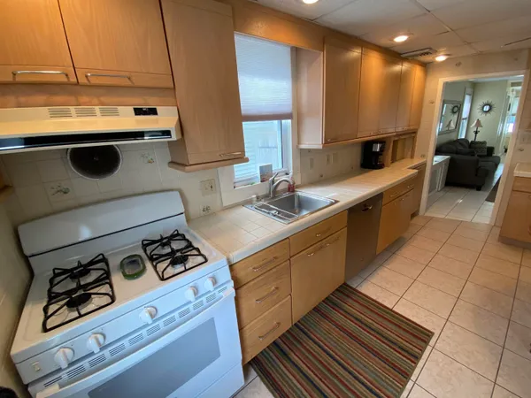 a kitchen with a sink a stove and cabinets