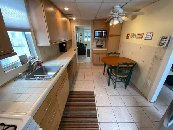 a kitchen with stainless steel appliances kitchen island granite countertop a sink and a refrigerator