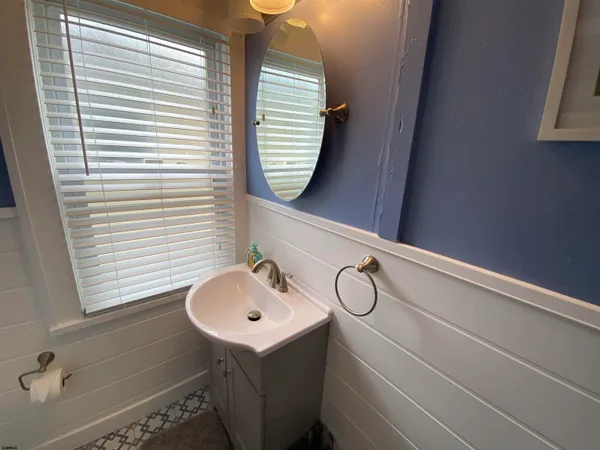 a bathroom with a sink a window and mirror