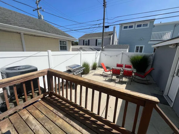 a view of a balcony with chairs and wooden floor