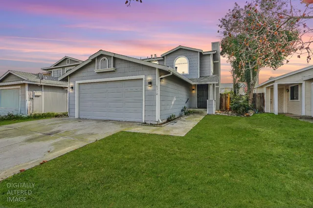 a front view of a house with a garden and yard