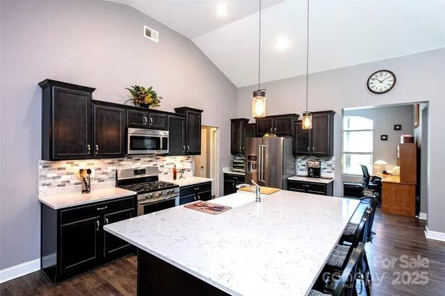 a kitchen with refrigerator and chairs
