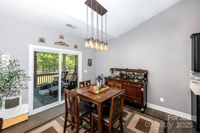 a view of a dining room with furniture a chandelier and wooden floor
