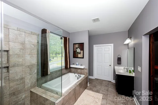 a bathroom with a tub a sink and mirror