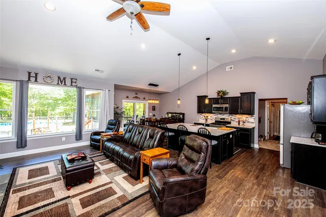 a living room with furniture a flat screen tv and a large window