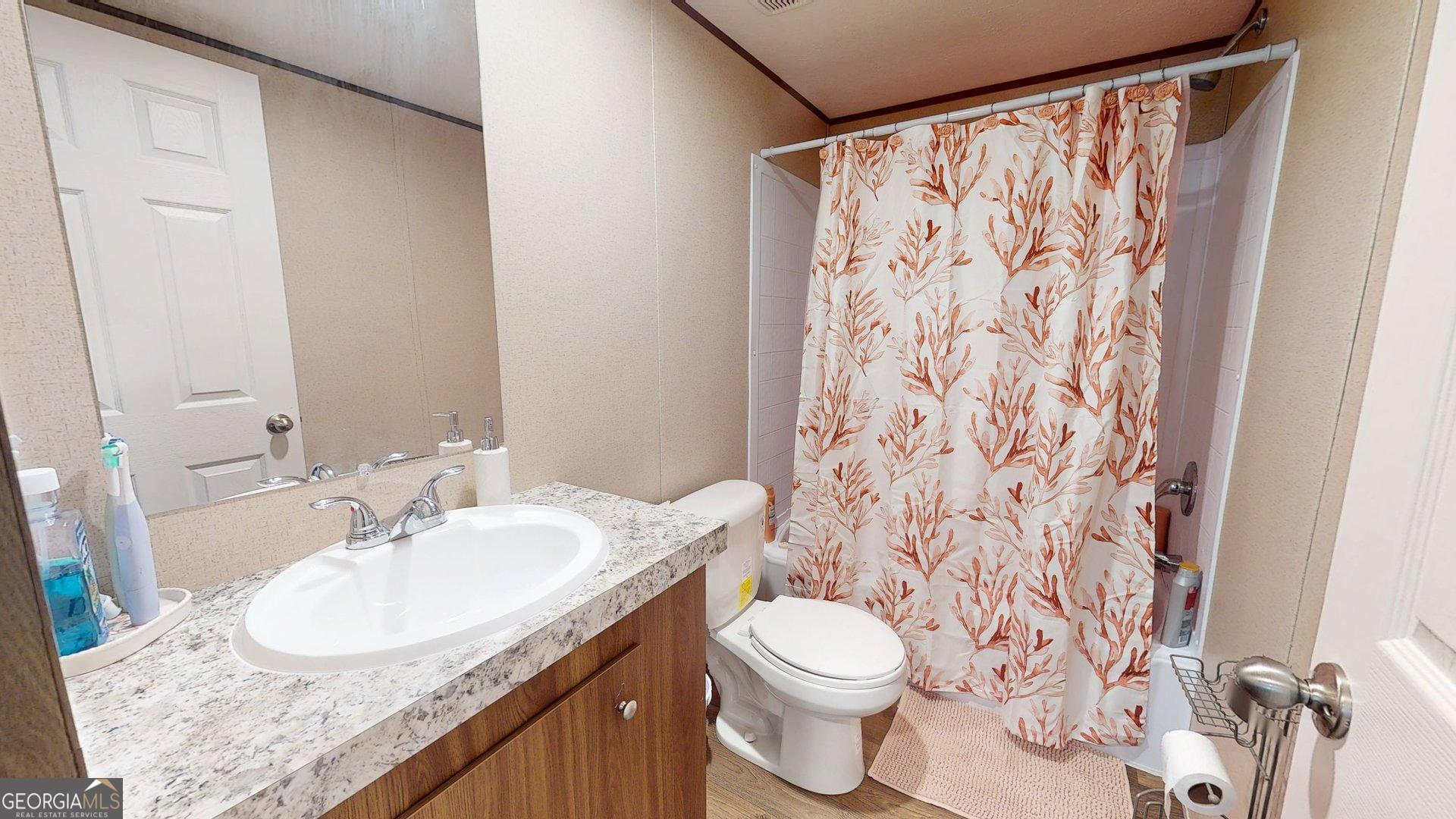 5571 Old Dixie Highway South Springfield, GA 31329 - Photo 11 of 38 a bathroom with a granite countertop sink a toilet and a mirror