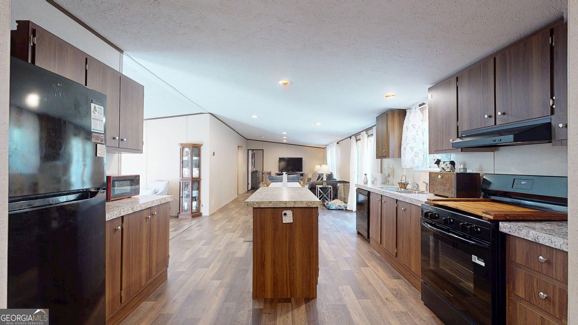 5571 Old Dixie Highway South Springfield, GA 31329 - Photo 34 of 38 a kitchen with stainless steel appliances granite countertop a stove refrigerator and a view of living room