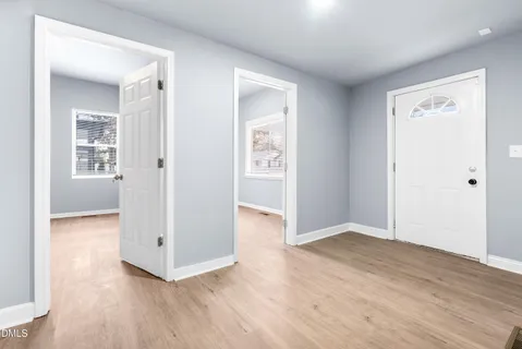 a view of empty room with wooden floor