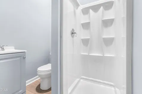 a view of a room with wooden floor and a bathroom