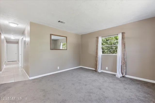 a bedroom with bed and a painting on the wall