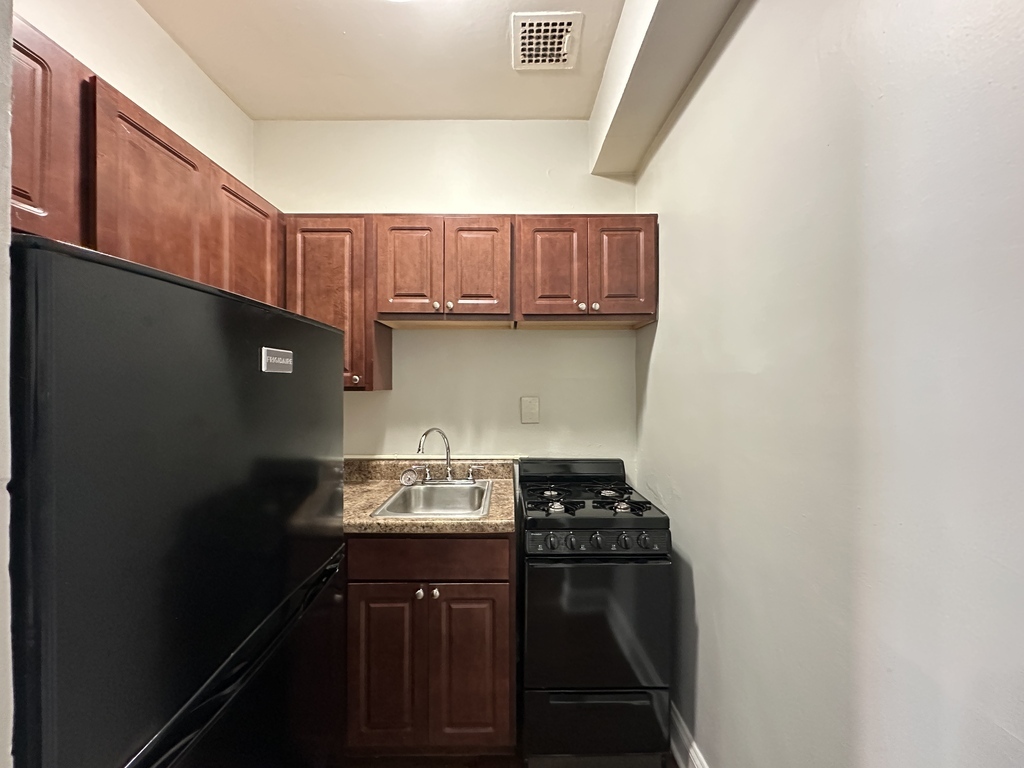 661 West Sheridan Road, Unit 208 Chicago, IL 60613 - Photo 2 of 20 a kitchen with a sink a stove and cabinets