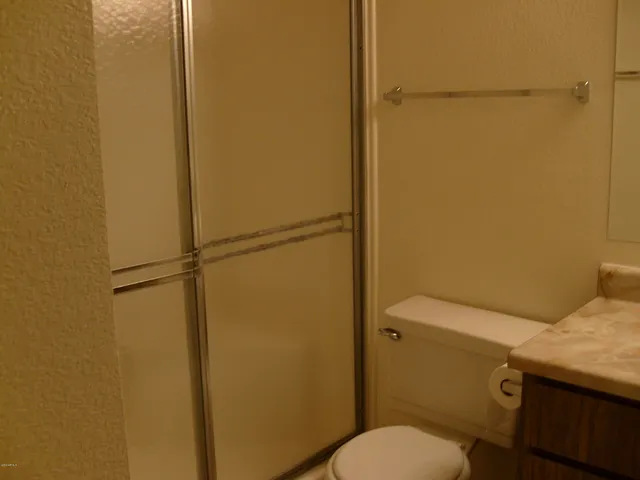 a bathroom with a granite countertop sink toilet and a mirror
