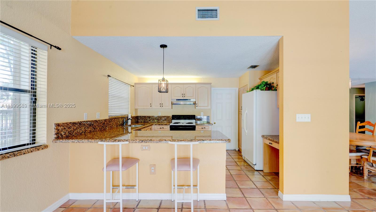 6255 Hawkes Bluff Avenue Davie, FL 33331 - Photo 24 of 51 a large kitchen with kitchen island granite countertop a refrigerator a stove a sink and a dining table with wooden floor