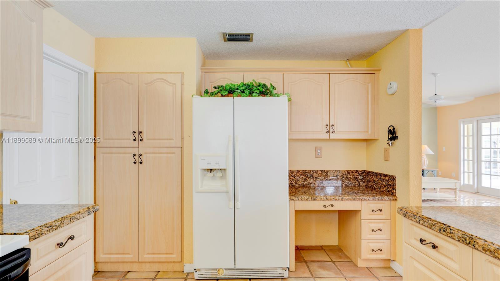 6255 Hawkes Bluff Avenue Davie, FL 33331 - Photo 28 of 51 a kitchen with a refrigerator stove and white cabinets