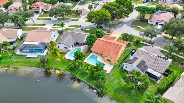 an aerial view of a house with a yard and lake view