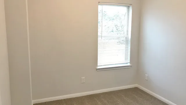 an empty room with closet and mirror
