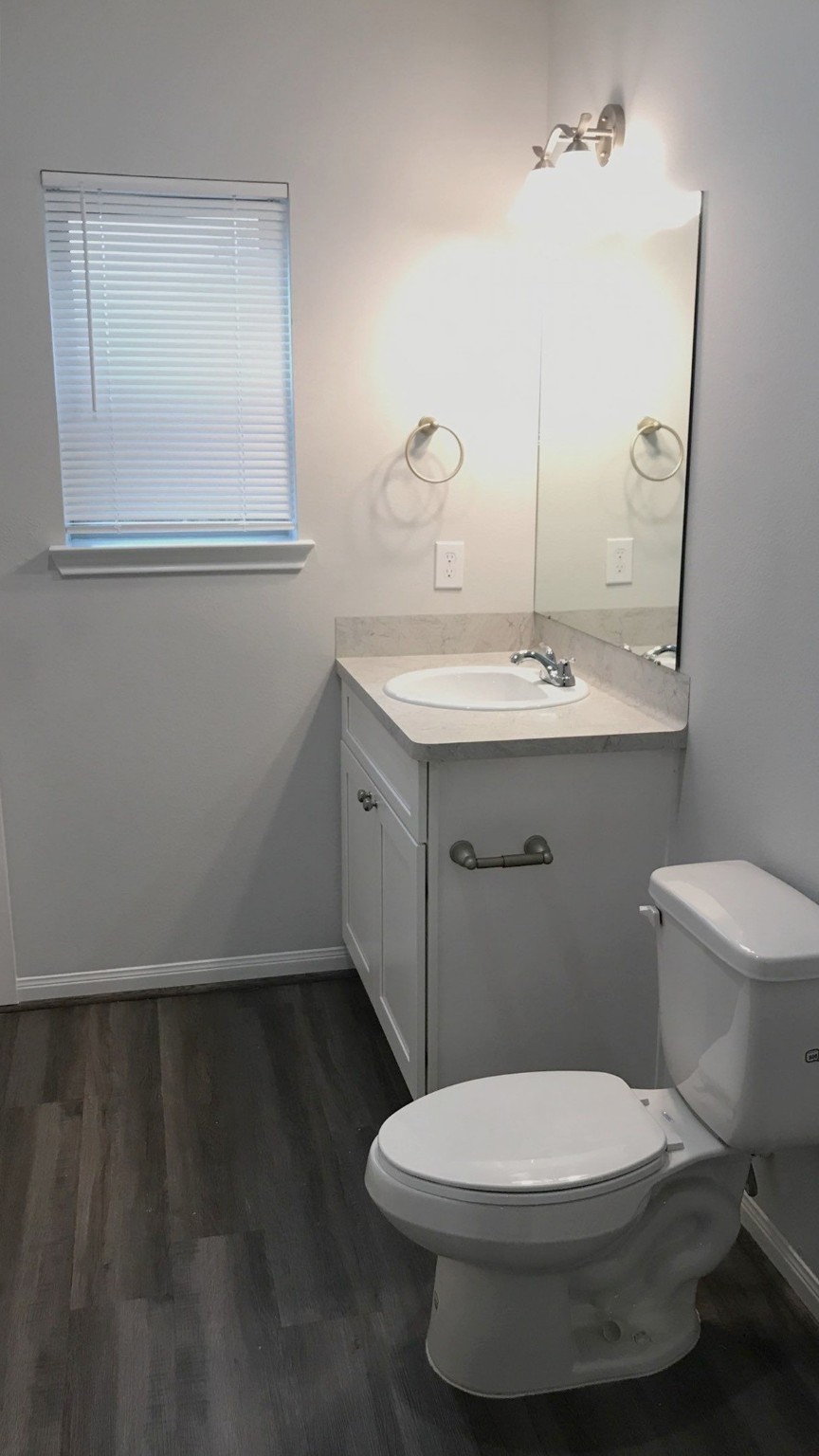7309 Price, Unit B Houston, TX 77088 - Photo 23 of 27 a bathroom with a toilet a sink and mirror