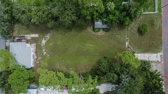 an aerial view of a house with a yard and large trees