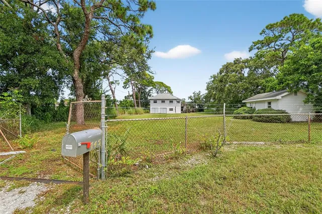 a view of a fountain in front of a house with a yard