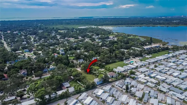 an aerial view of a houses with a yard and lake view