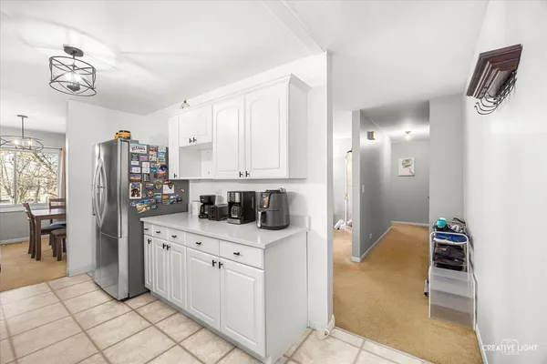 a kitchen with white cabinets and refrigerator