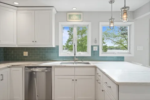 a kitchen with a sink window and cabinets