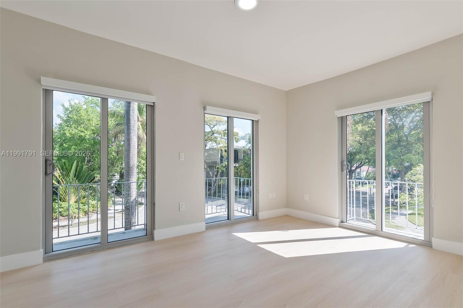694 Northeast 76th Street, Unit 6 Miami, FL 33138 - Photo 15 of 35 a view of an empty room with wooden floor and a window