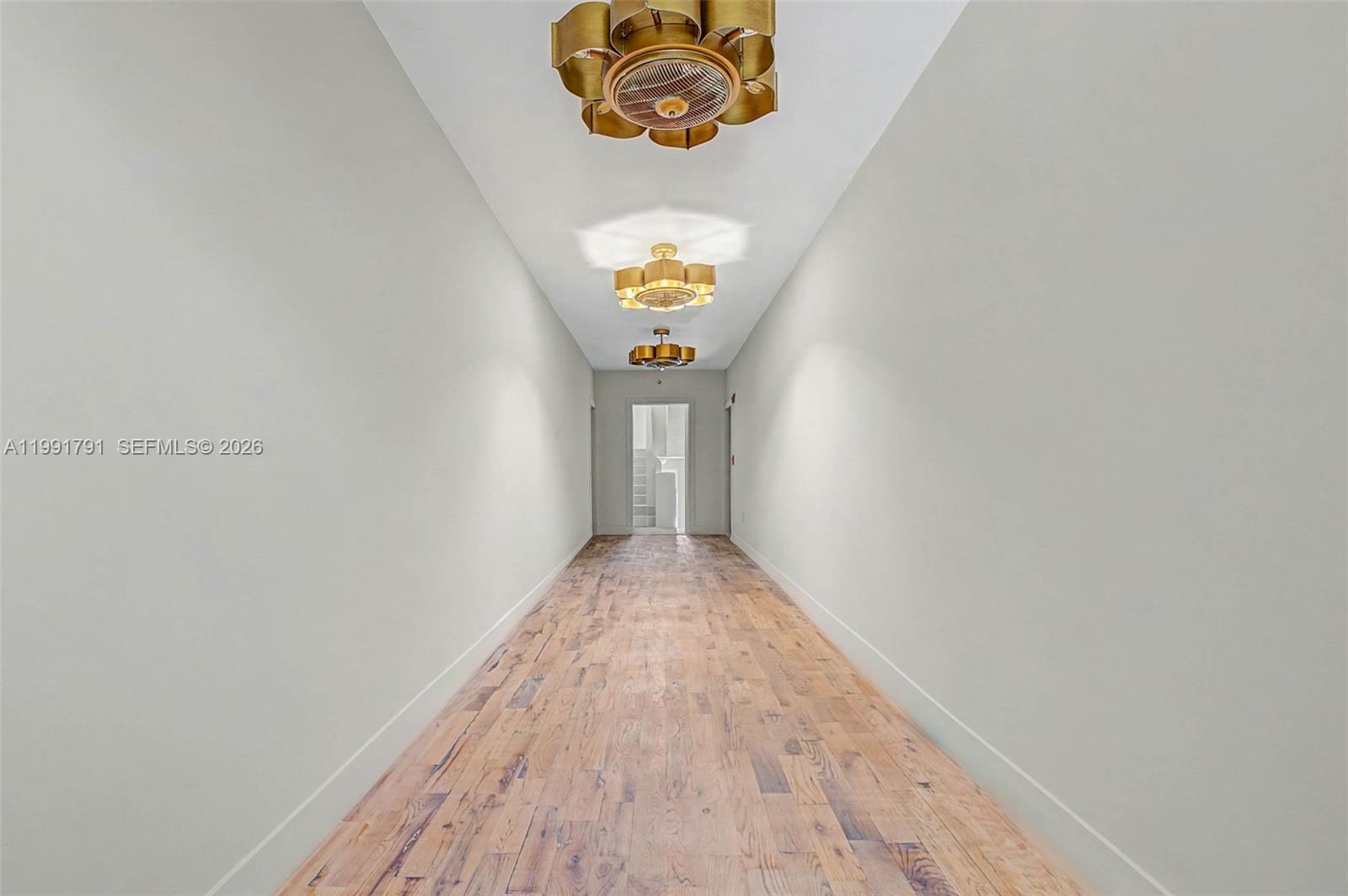 694 Northeast 76th Street, Unit 6 Miami, FL 33138 - Photo 29 of 35 a view of a hallway with wooden floor