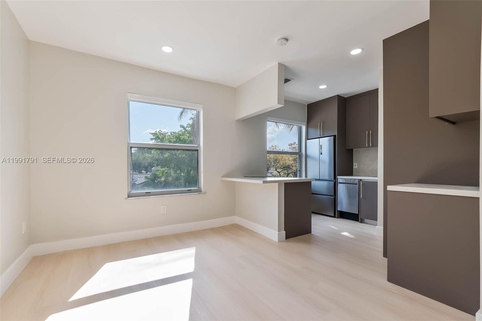 694 Northeast 76th Street, Unit 6 Miami, FL 33138 - Photo 5 of 35 a large white kitchen with a refrigerator a sink dishwasher and a stove
