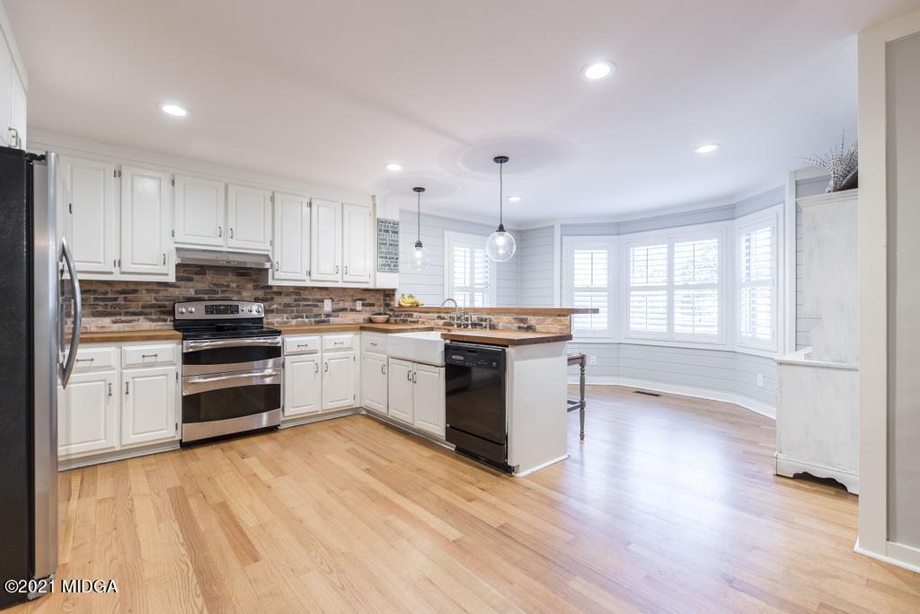 7085 Colaparchee Road Macon, GA 31220 - Photo 15 of 57 a kitchen with granite countertop a stove top oven and cabinets