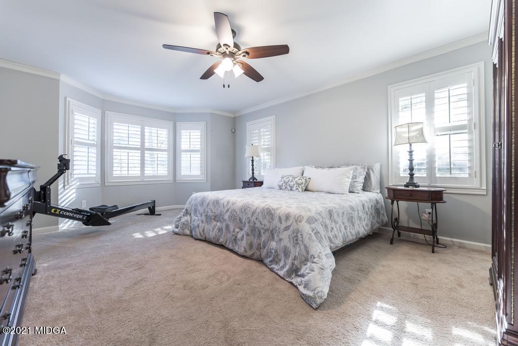 7085 Colaparchee Road Macon, GA 31220 - Photo 27 of 57 a spacious bedroom with a bed a chair and potted plant on the dresser