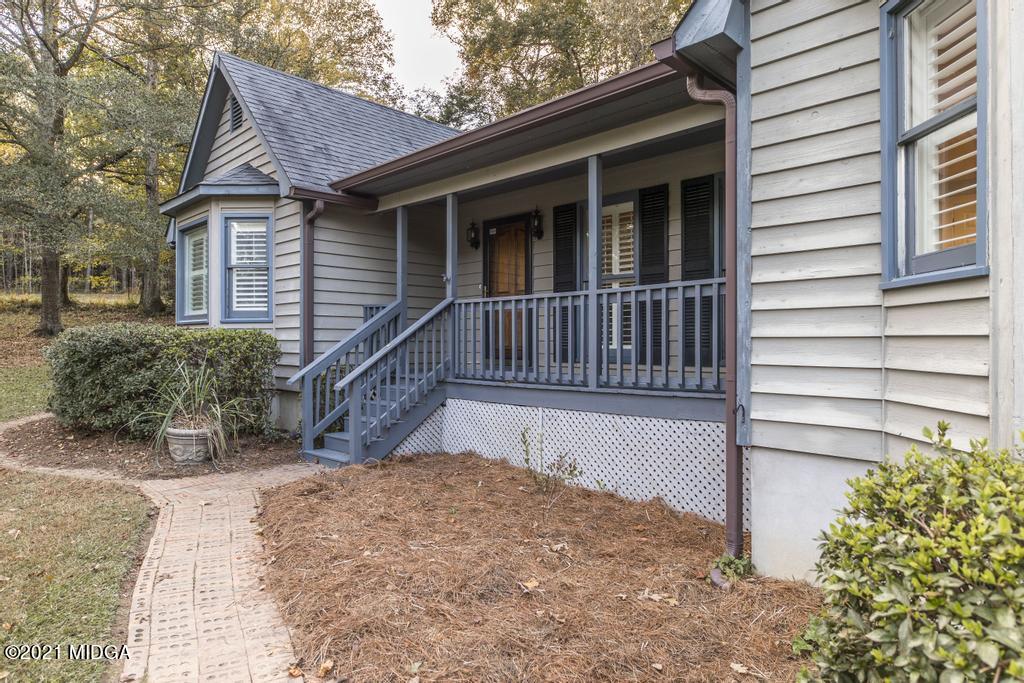 7085 Colaparchee Road Macon, GA 31220 - Photo 9 of 57 a view of wooden house with a large window and potted plants