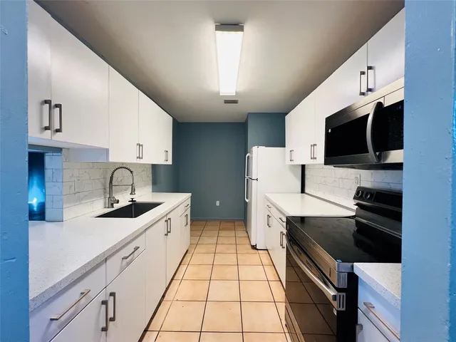 a kitchen with a sink cabinets and appliances