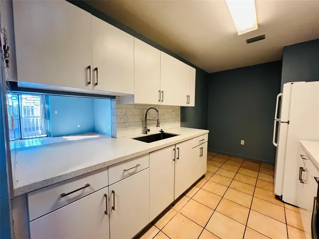 a kitchen with stainless steel appliances a stove a microwave and white cabinets