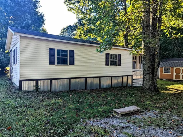 a view of a house with backyard and sitting area
