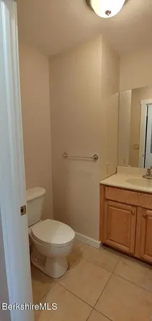 a bathroom with a granite countertop toilet and a sink
