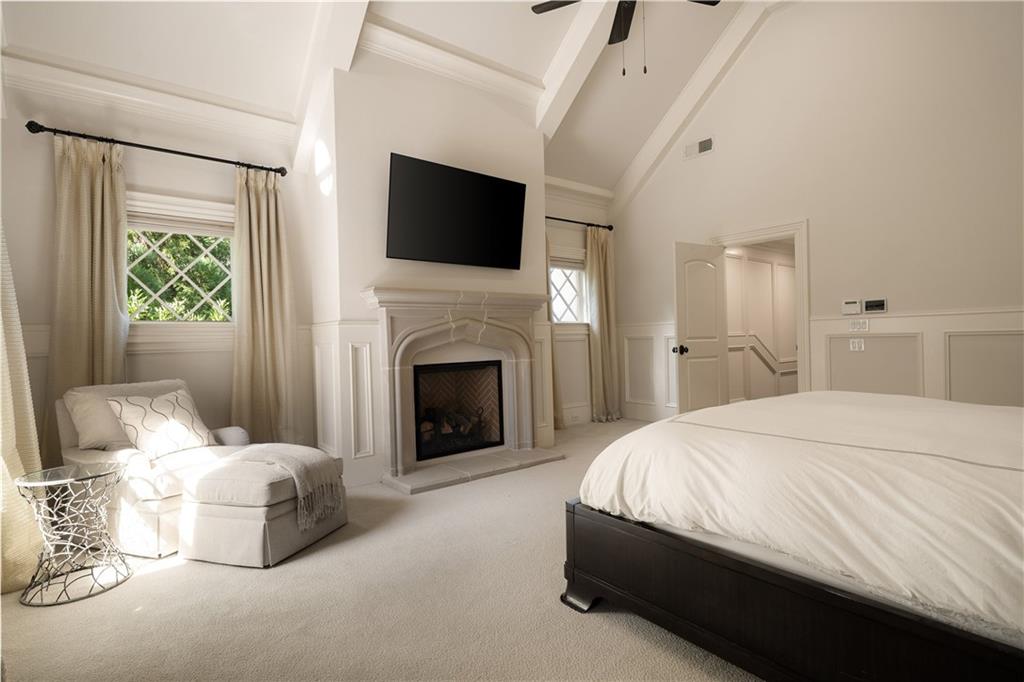 4136 North Stratford Road Northeast Atlanta, GA 30342 - Photo 34 of 78 a spacious bedroom with a bed and a fireplace